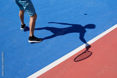Faceless tennis player captured in motion on an outdoor court. 