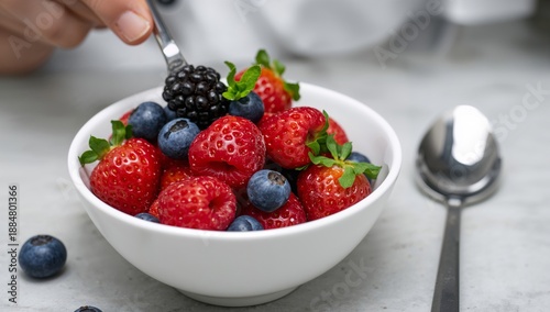 Fresh Berries Served in White Bowl During Breakfast at Kitchen Table in Morning