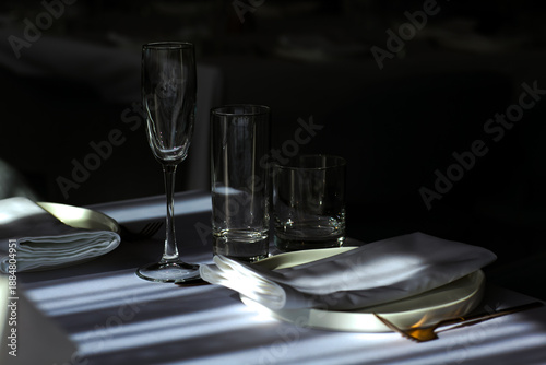 Beautiful table setting with dishes,in a restaurant,light-shadow pattern and style