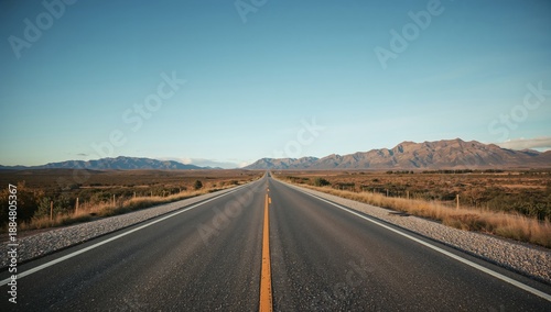Wide Open Road Stretching Into Mountains Under Clear Sky With No Vehicles in ...