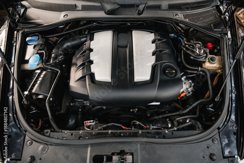 Car with open hood close up to camera. Maintenance in auto repair shop. Car service, repair, maintenance concept. Selective focus.