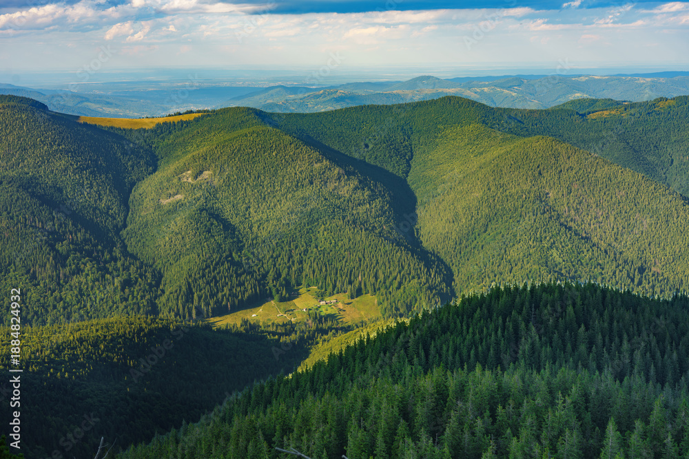 Obraz premium Wide panoramic aerial mountain landscape with dense green coniferous forests rolling hills and dramatic clouds ideal for travel, tourism, nature hiking and outdoor concepts. Carpathians, Ukraine
