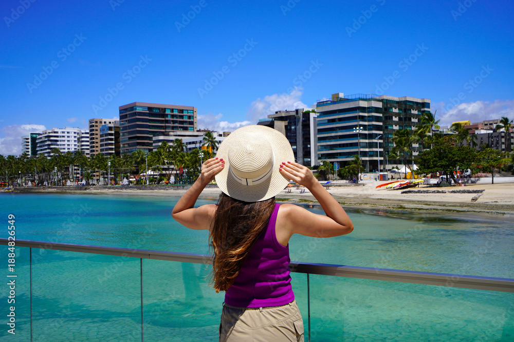 Fototapeta premium Vacation in Brazil. Back view of young woman enjoying sight on belvedere in Maceio, Alagoas, Brazil.