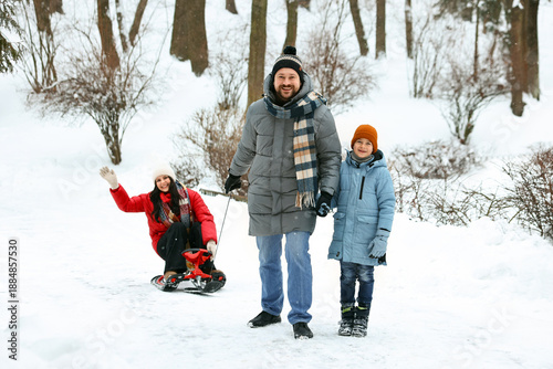 Canvastavla Happy family having fun with sledge outdoors on winter day