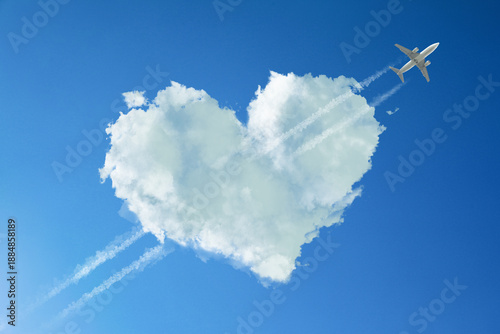 Cute fluffy heart-shaped cloud with plane flying through it as piercing arrow in blue sky