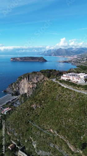 Spectacular vertical drone footage of Dino Island near Praia a Mare Calabria showcasing the coast and the contrast between the blue sea and green mountains