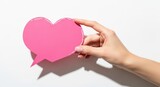 Woman hand holding pink heart shaped speech bubble with copy space. Valentine day or social media like concept.
