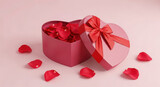 Open heart shaped pink gift box with red bow and rose petals