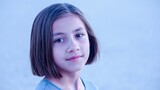 Young girl with bob cut hairstyle looking directly at camera, portraying innocence and youth