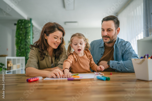 Happy family enjoying creative activity drawing with daughter