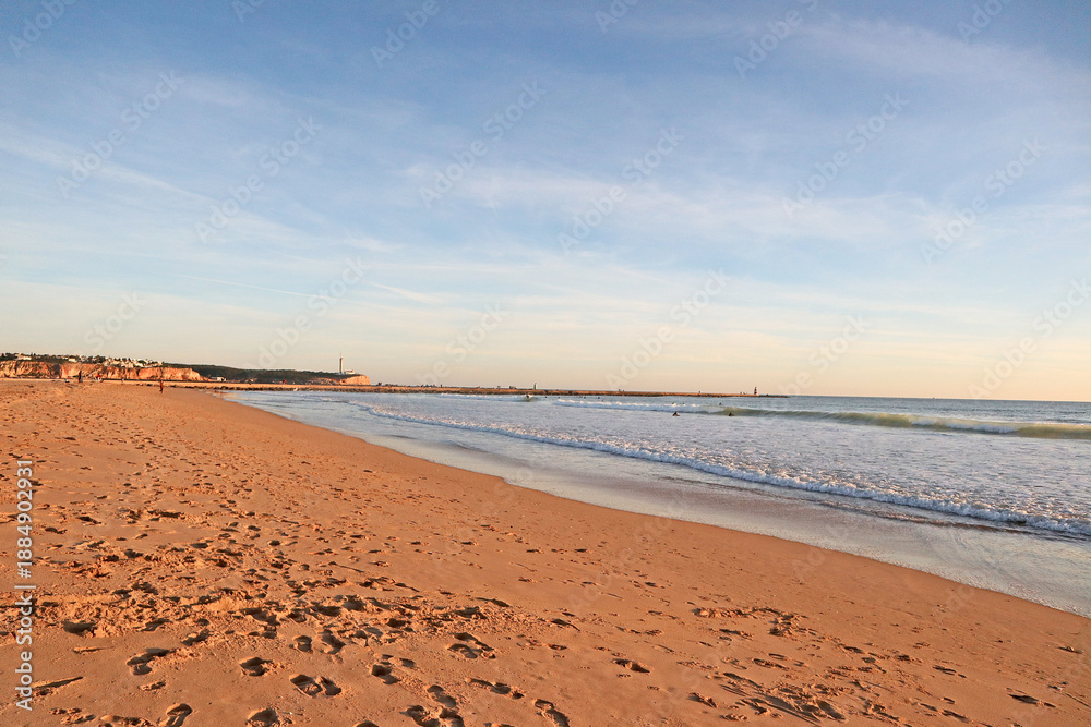 Obraz premium View of the calm ocean on a clay beach right before sunset