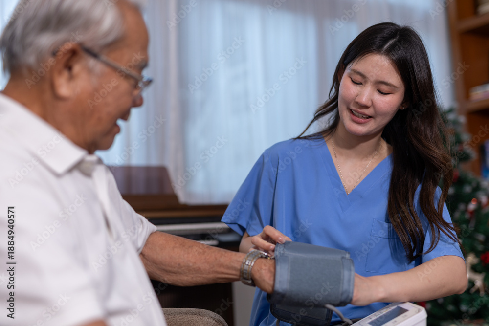 Obraz premium Asian nurse measuring blood pressure of senior man at home using digital monitor. Concept of elderly healthcare, home medical service and regular health check for aging population.