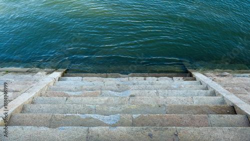 Old damaged concrete steps that descend into the river