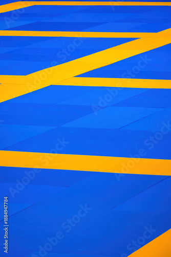Bright blue and yellow floor design with geometric pattern in a modern space to practice martial arts