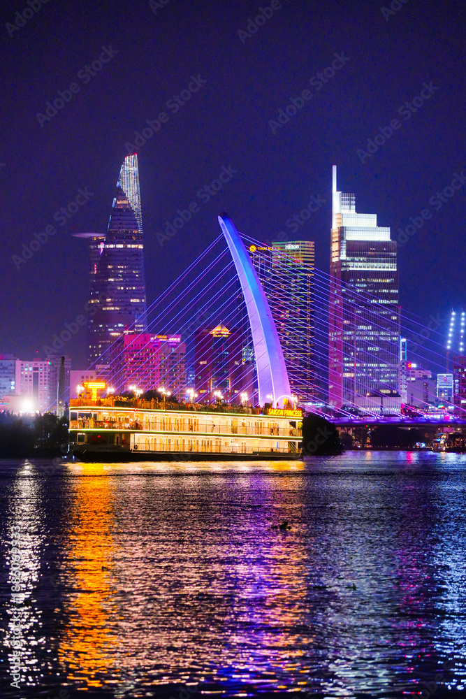 custom made wallpaper toronto digitalNight view of Bitexco Tower, colorful buildings, Bason bridge and Saigon river in Ho Chi Minh city, tourist boats and cruises on Saigon river
