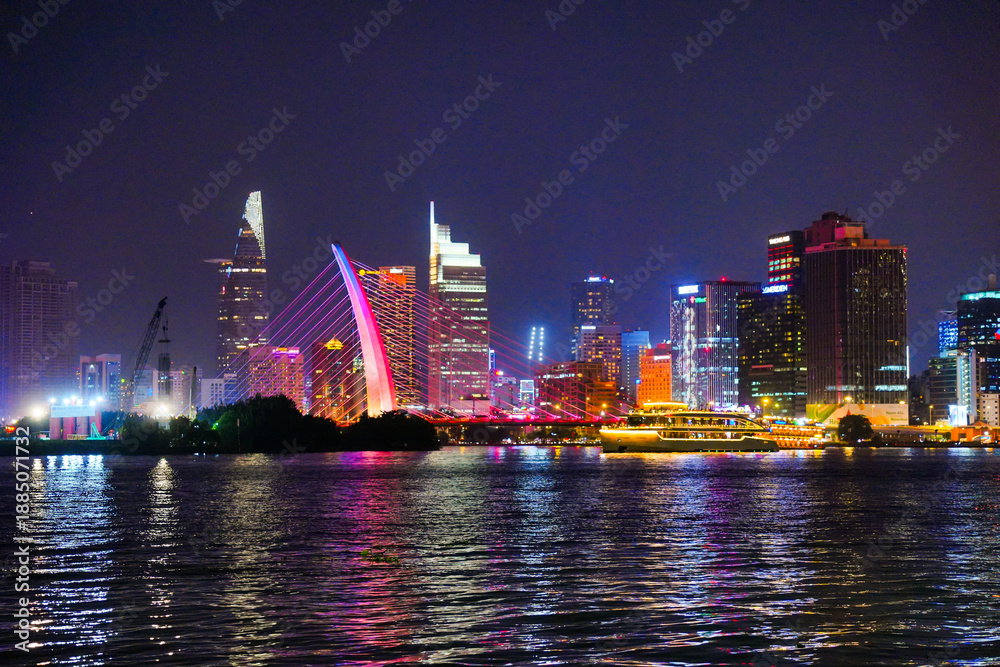 custom made wallpaper toronto digitalNight view of Bitexco Tower, colorful buildings, Bason bridge and Saigon river in Ho Chi Minh city, tourist boats and cruises on Saigon river