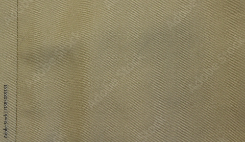 Beige fabric texture. Beige fabric used for trench coat background. Close-up of beige cloth with vertical seam.