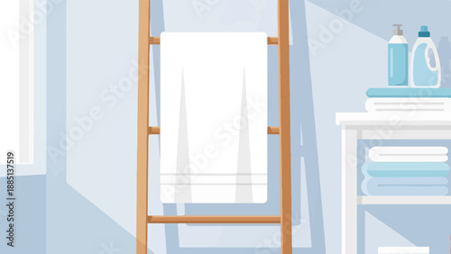 A clean white towel hangs on a wooden rack next to neatly folded laundry
