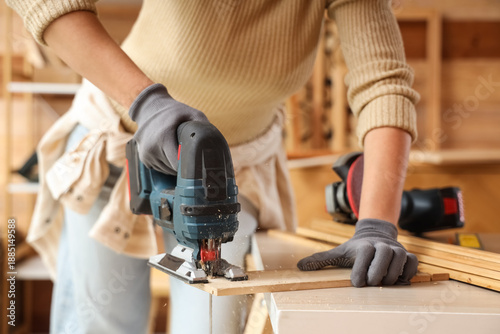 Young female carpenter sawi...