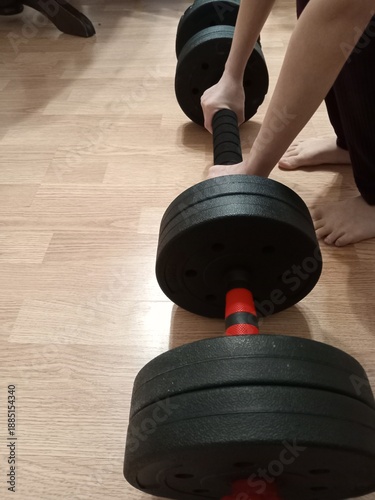 youn girl lifting weights, doing fitness at home for kids