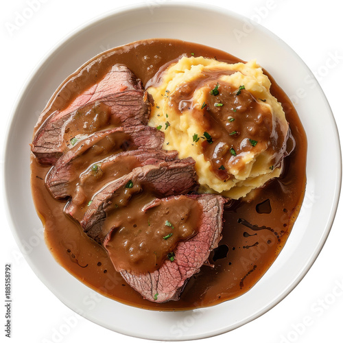 Sliced roast beef with gravy served alongside creamy mashed potatoes on a plate isolated on white background