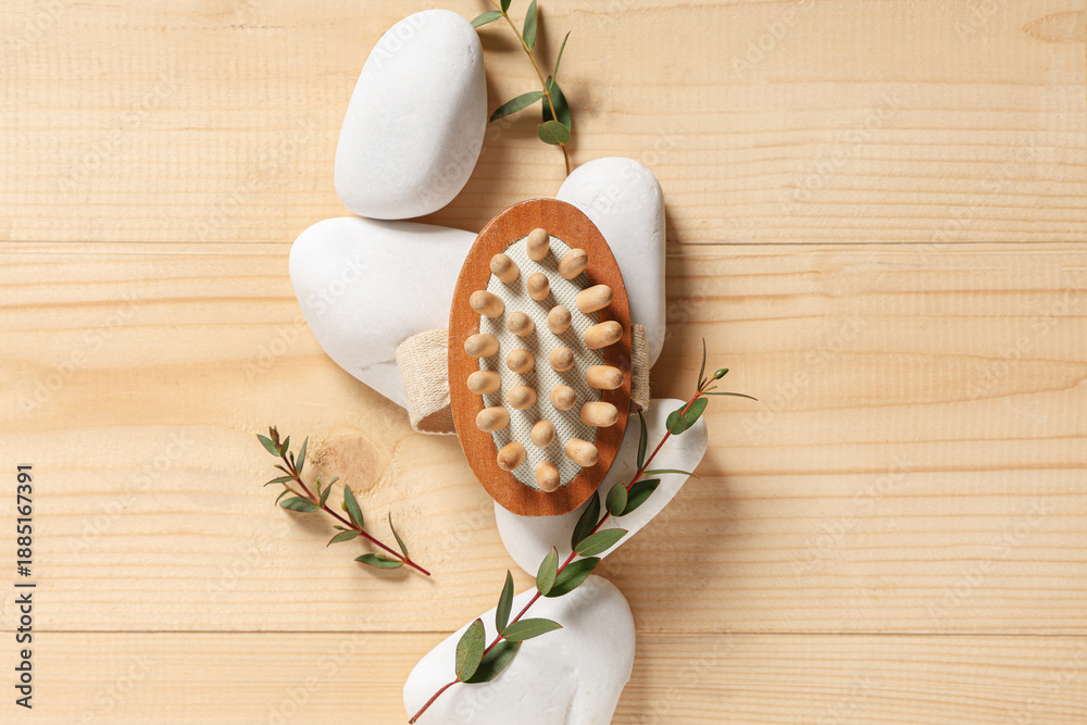Fototapeta premium Composition with bottle of cosmetic product, massage brush, spa stones and eucalyptus branches on wooden background