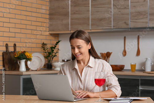 Young woman using laptop at...