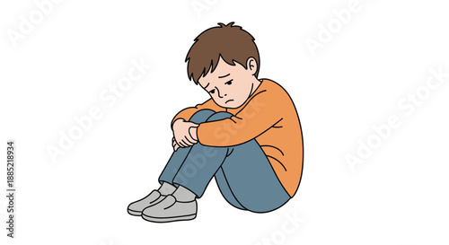 Sad and lonely young boy sitting on the floor hugging his knees and looking down expressing feelings of sadness or depression.