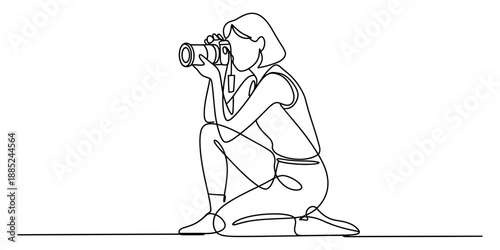 Continuous line drawing of a woman photographer kneeling and taking pictures with a camera