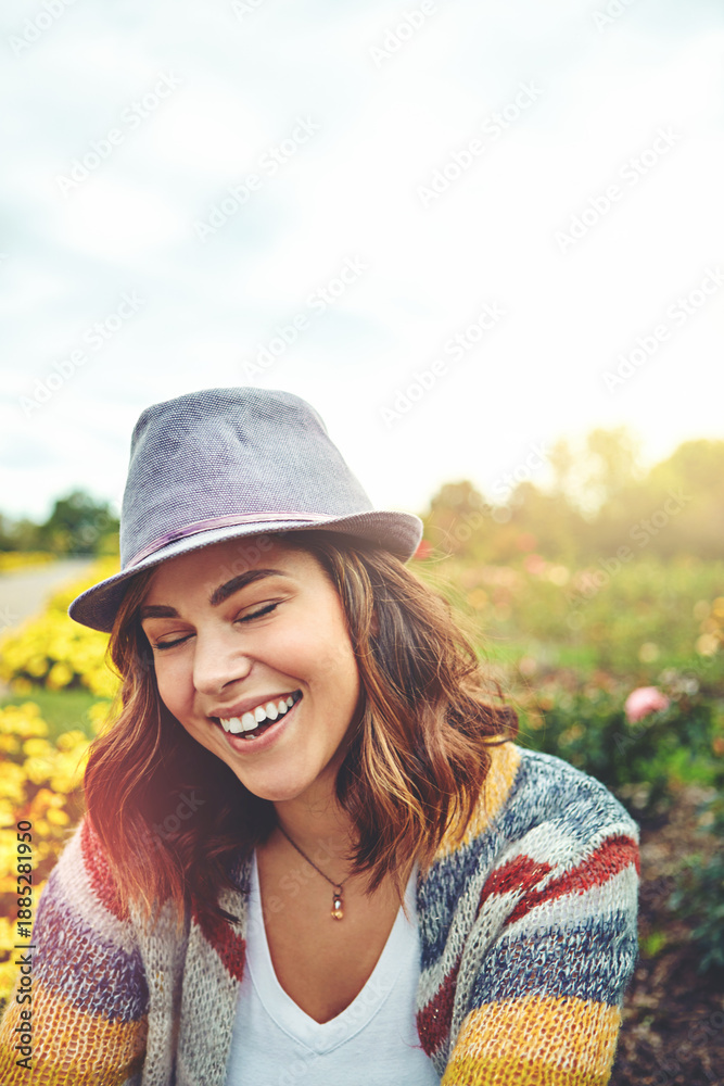 Fototapeta premium Confident, woman and smile outdoor for travel, spring adventure and holiday trip. Space, female person or explore nature with floral daisies, sunshine and fresh air on vacation getaway in countryside