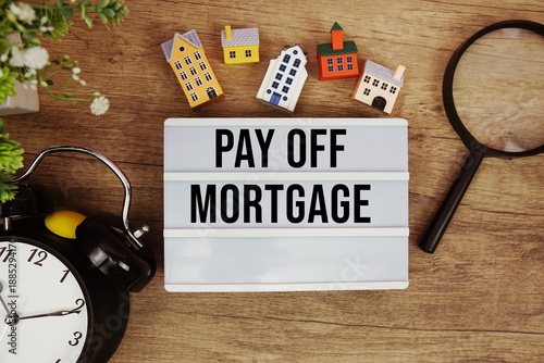 Konstfotografi Pay Off Mortgage text in lightbox with house model, magnifying glass and alarm c