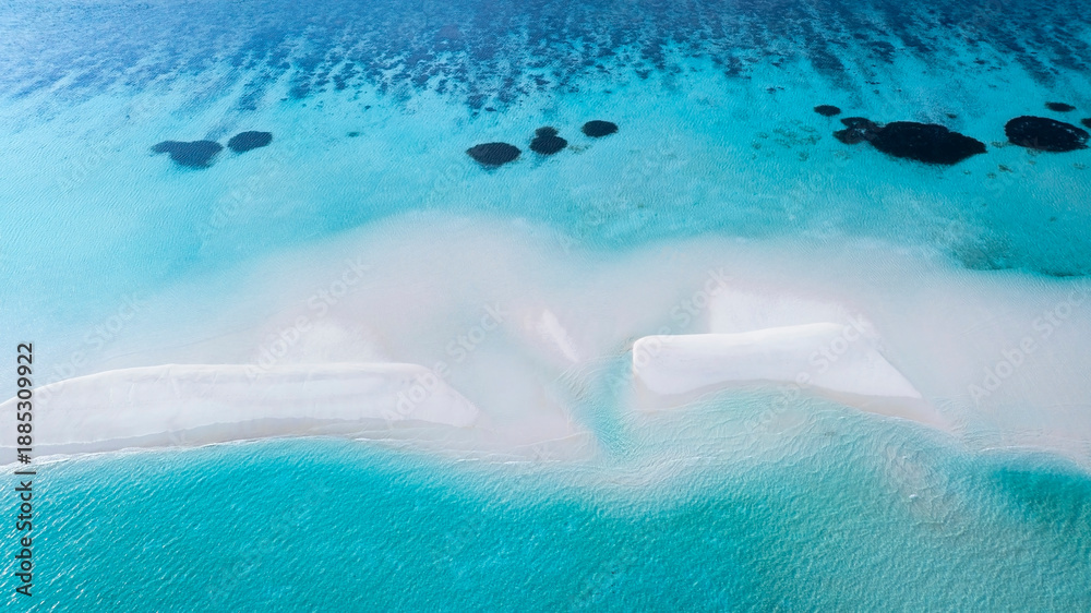 Fototapeta premium Aerial view with crystal clear with summer lagoon ripples in the sand at low tide on a beach with sandbar and blue sea in Raja ampat,indonesia