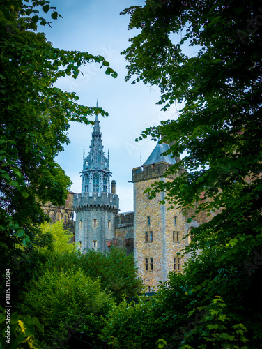 фотографія Fairytale turrets of Cardiff Castle in Wales, UK nicely framed by full summer lu