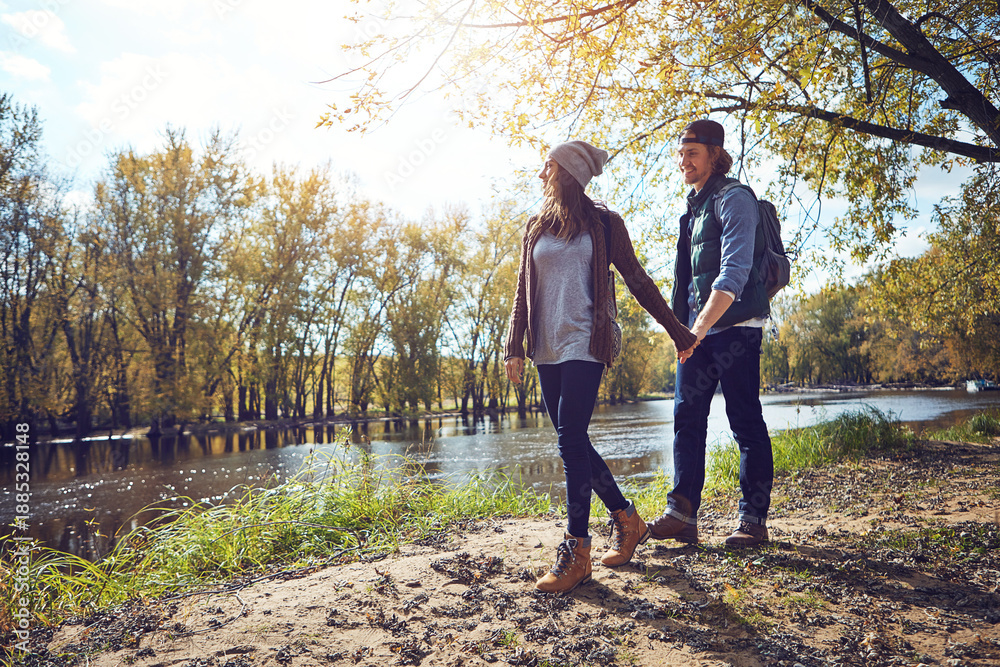 Obraz premium Couple, walk and holding hands on hike, forest and happy with partner in nature, trekking and travel. Outdoor, hikers and people on journey in woods, backpacking and exploration on holiday or trip