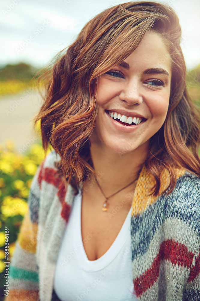Fototapeta premium Thinking, woman and smile outdoor for travel, spring adventure and holiday reflection. Happy, female person and vision in nature with floral daisies, sightseeing and vacation getaway in countryside