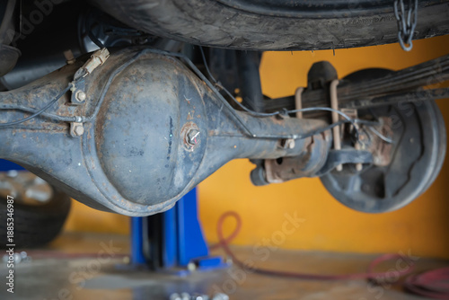 Bild auf Leinwand Close-up of rusty car rear differential axle housing and leaf spring suspension