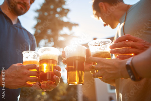 People holding beer cups and enjoying summertime outdoors.