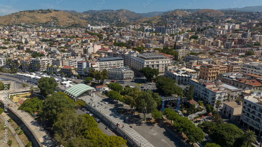 Obraz premium Aerial view of the historic center of Reggio Calabria, Italy. In the foreground is the tree-lined promenade of the city. It is a sunny summer morning.