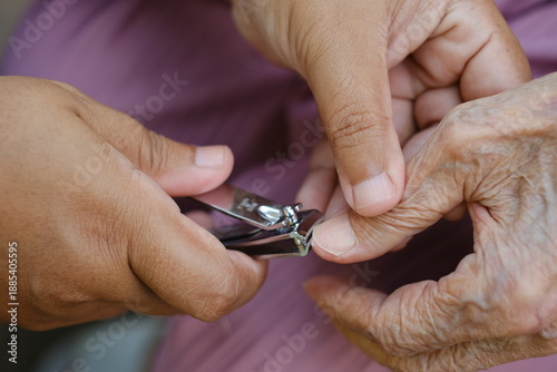 Background image of someone trimming nails for an elderly person.