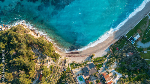 Photography Top down aerial view of a sand beach and houses next to the calm sea on Samos is
