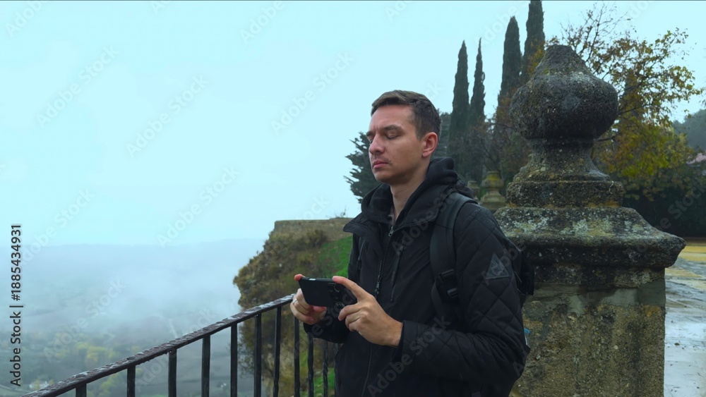 Fototapeta premium Traveler Photographs Misty Scenery Retrospectively, Explorer Documents Gloomy Valley With Camera Focus . Action