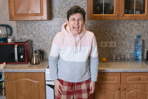 Canvas-taulu Woman in casual hoodie screaming with clenched face and tense posture in a kitch