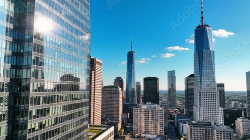 Modern skyscrapers in a city skyline under a clear blue sky with clouds