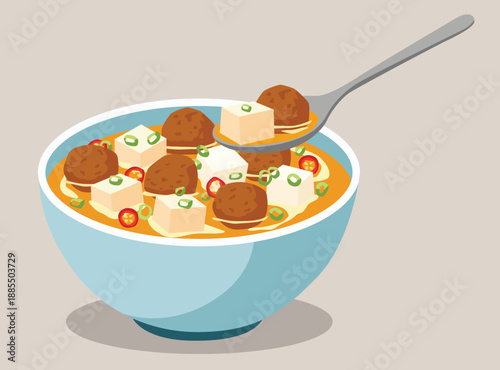 meatball and tofu soup in a blue bowl. Features spicy broth, scallions, and red chili. A spoon lifts out a savory meatball and a tofu cube.