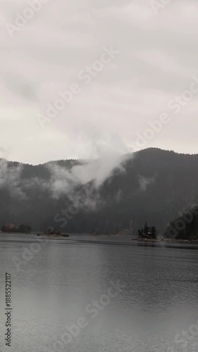 A powerful horizontal shot of rocky alpine summits disappearing into dense low clouds.