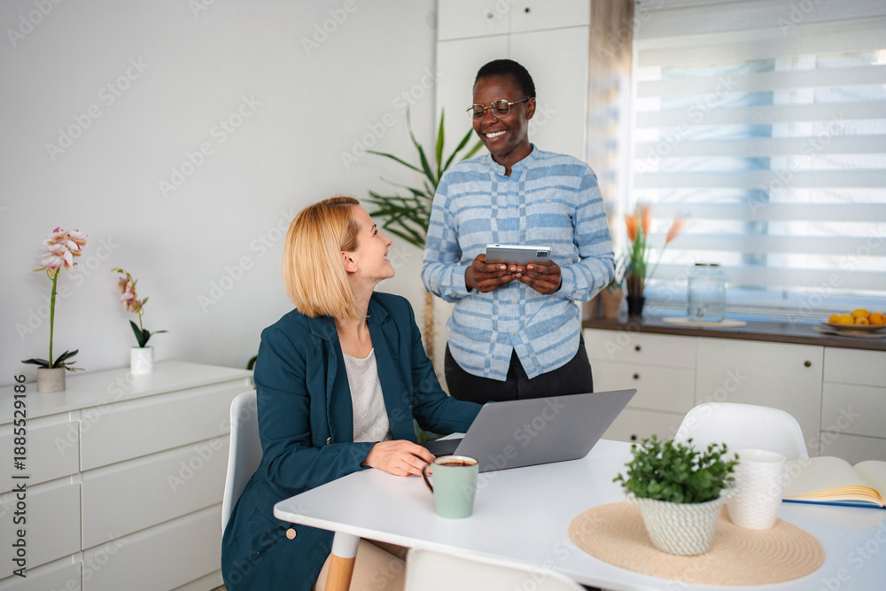 Fototapeta premium Diverse women colleagues collaborating remotely on business project at home