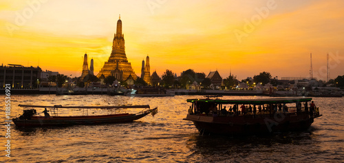 Riverboats at sunset,next to the Arun Temple,along the Cha Phraya River,Bangkok.