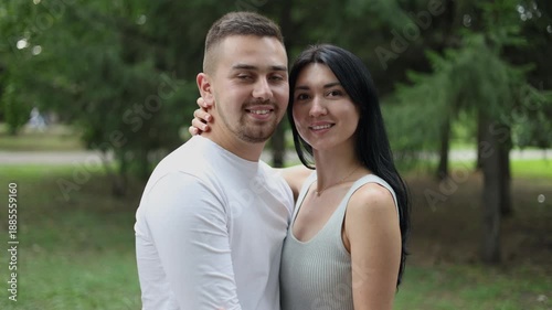 A young couple in love hugs each other with tenderness and love. A happy couple in love looks straight ahead.