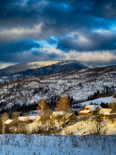 Mystical snowy Carpathian peaks under cloudy skies in the sunny weather
