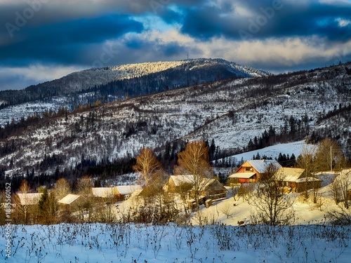 Mystical snowy Carpathian peaks under cloudy skies in the sunny weather